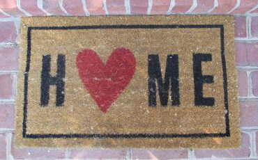 An image of a doormat with the word Home on it to support a new article from Jameson and Partners estate agents in Altrincham called Focus on these 6 Tips for success selling your home